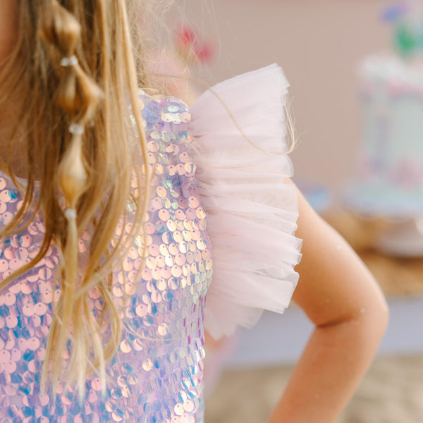Child wearing a sequined dress with a blurred background