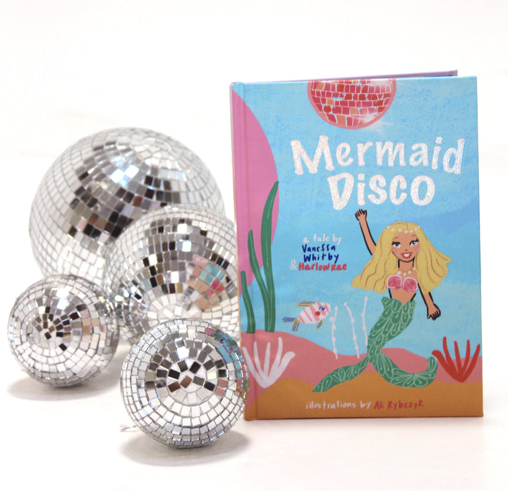 Silver disco balls with a 'Mermaid Disco' book on a white background