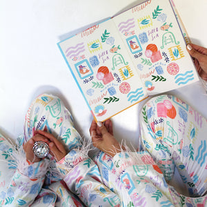 Person wearing a colorful pajama set holding a decorated notebook.