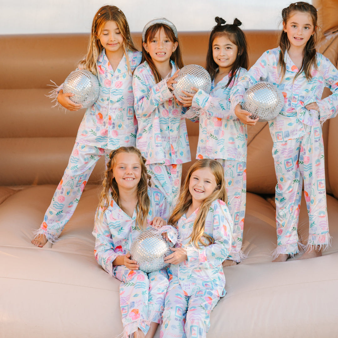 Children in matching pajamas with disco balls on a couch