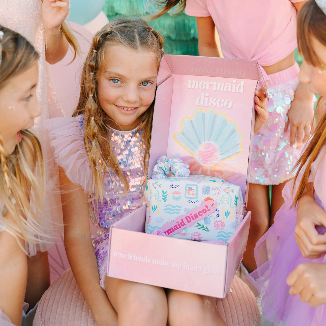 Children in mermaid-themed outfits with a 'mermaid disco' box